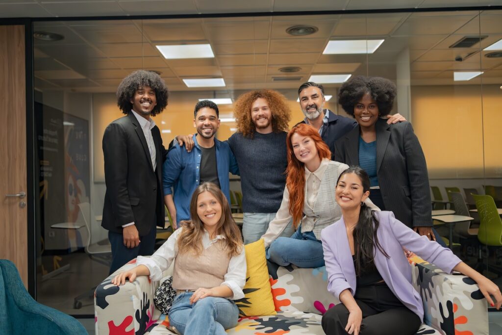 A portrait of a diverse team smiling to reflect a positive workplace culture.